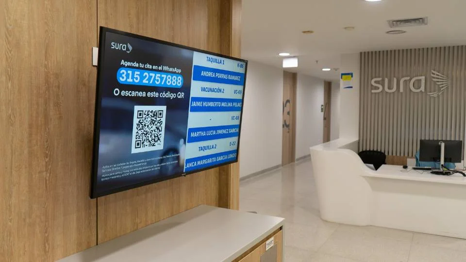 Tela na recepção exibindo um grande código QR para agendamento de forma remota via WhatsApp